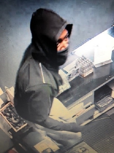 Wanted suspect wearing a dark hoodie and a dark face mask, covering the lower half of his face