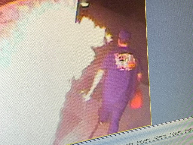 Security footage of arson suspect walking away from a fire with a gas can.