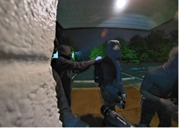 Multiple people in dark clothing and masks.
