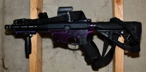 A short-barreled rife mounted to a wall.