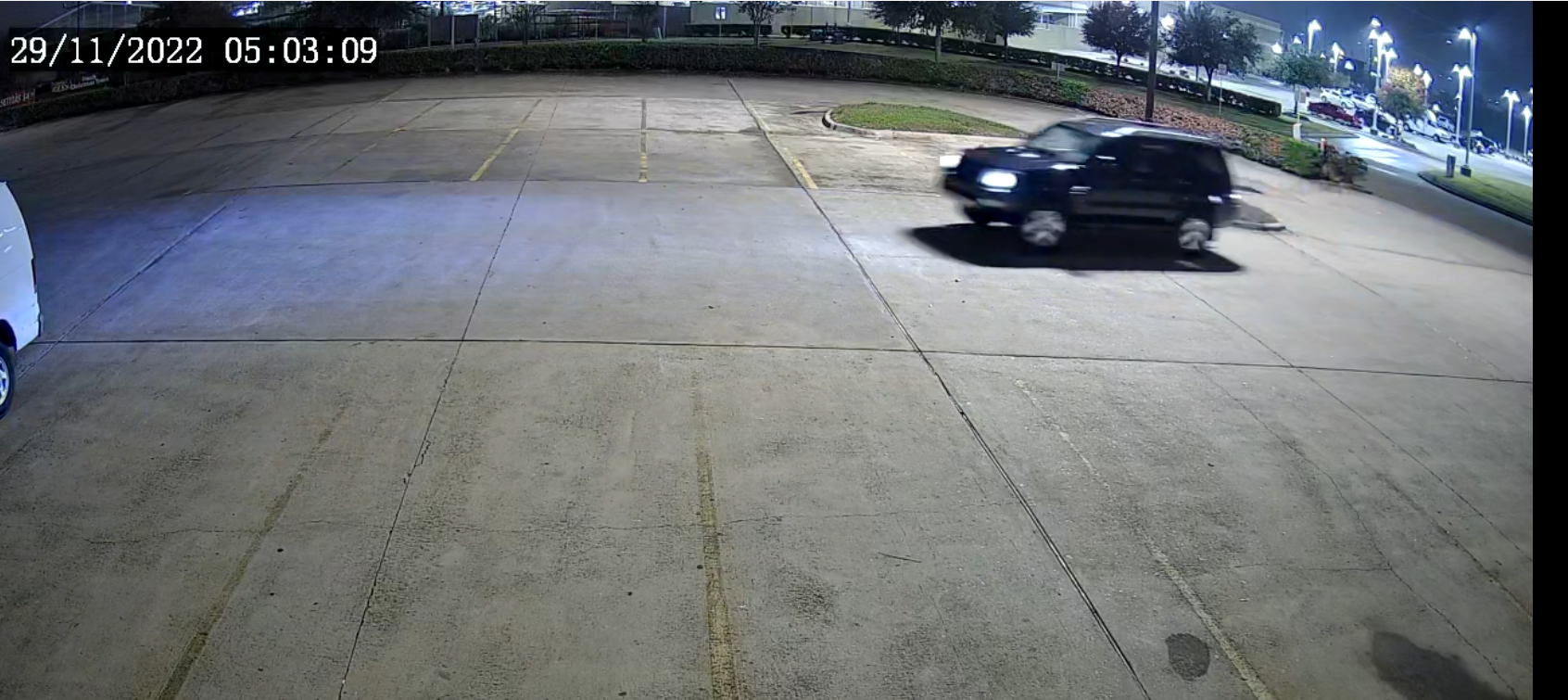 A dark-colored car in a parking lot at 5:03am on November 29, 2022.