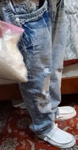 Man holding a gallon bag of drugs