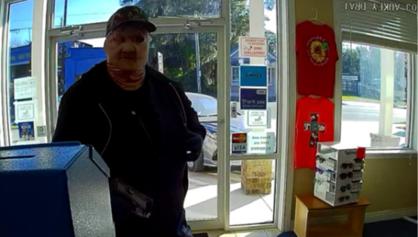 Photo of masked individual that was captured on surveillance cameras walking into the pharmacy with a black handgun, and demanding controlled substances, specifically, oxycodone, OxyContin, and Percocet. 