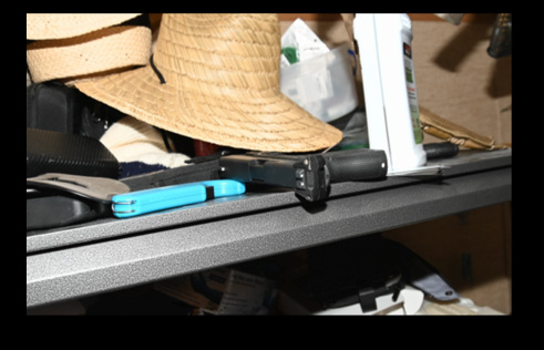 Photo of law enforcement seized articles of clothing, multiple masks, the firearm, handwritten notes, and brown boots associated with the robberies.