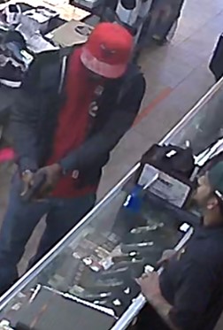 Wilson holding and inspecting a firearm at an FFL in January 2023