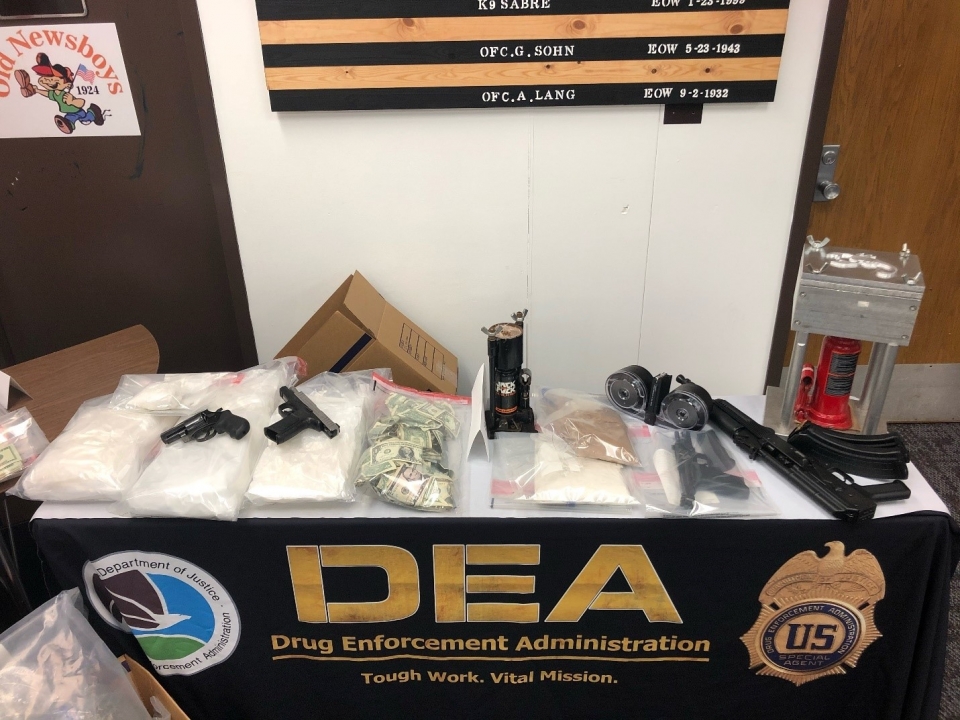Guns and money seized lying on a DEA table