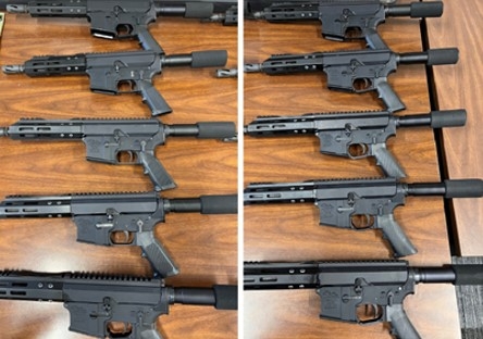 Closeup of multiple guns laying on a table