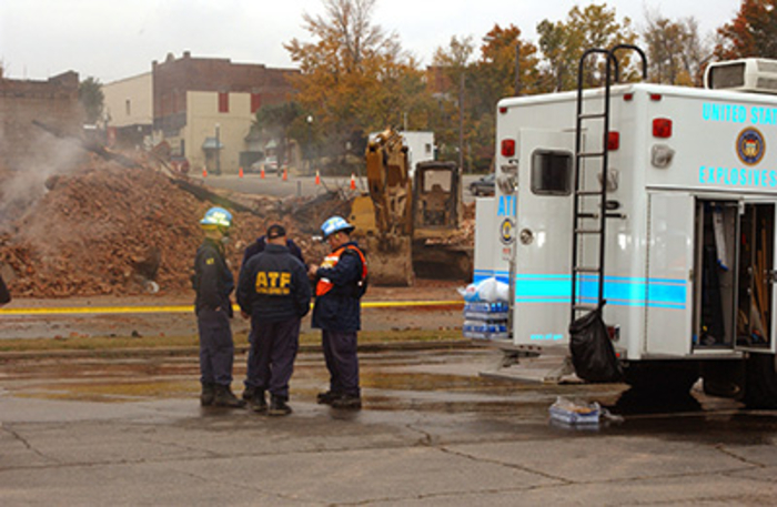 Four agents talking behind the ATF truck at an undisclosed area during an investigation