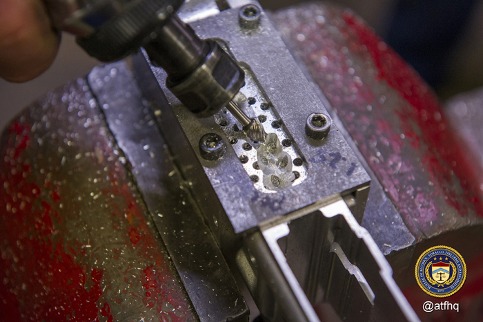 Removing material from fire control cavity with rotary tool
